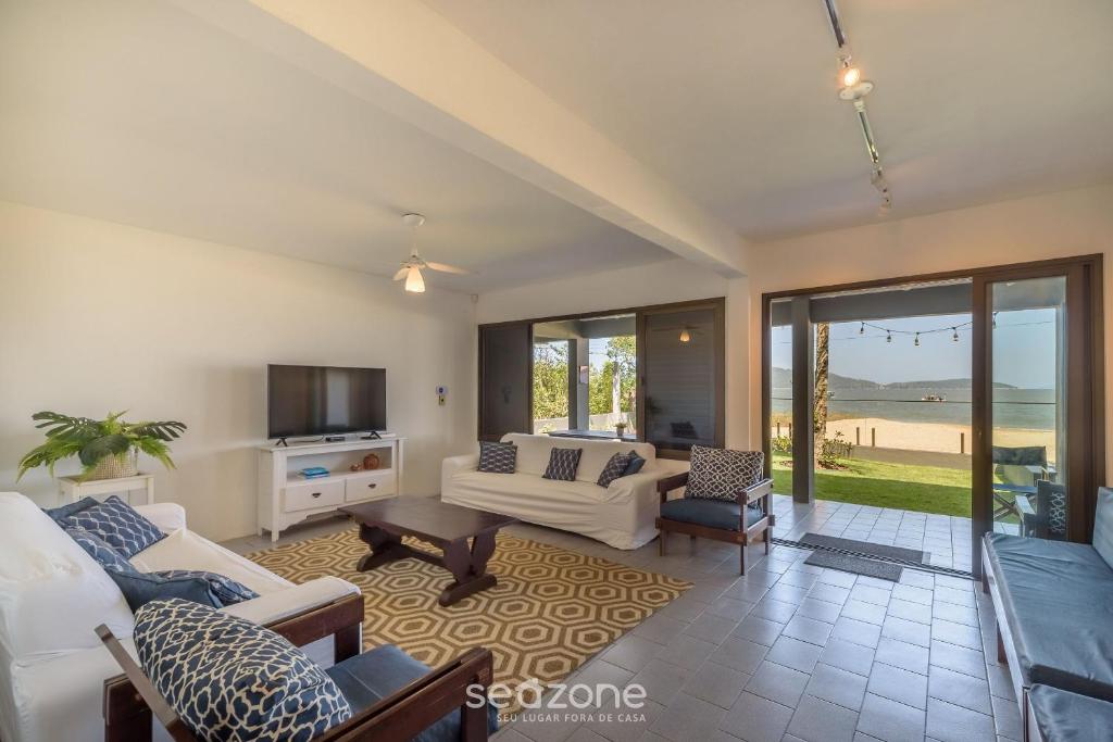 a living room with a couch and a table at Casa 6Q pé na areia em Bombinhas ABM0101 in Zimbros