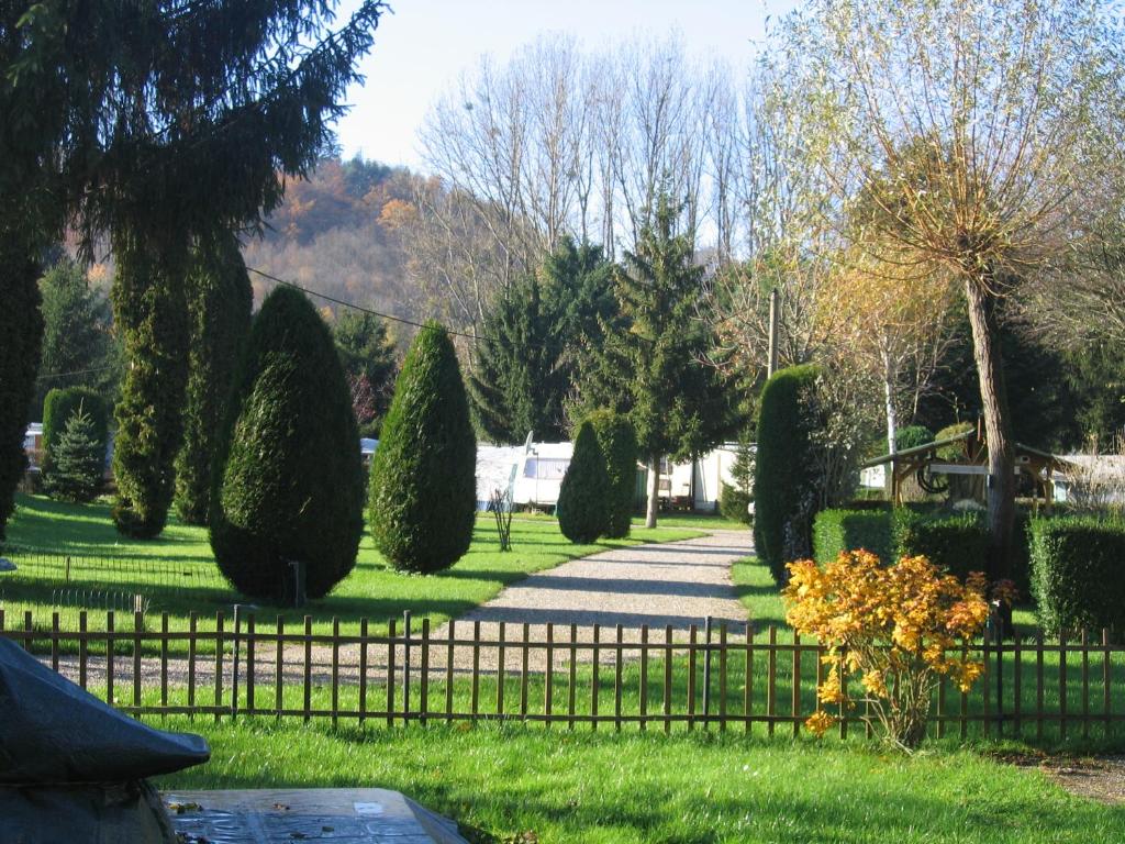 un jardin avec une clôture, des arbres et une passerelle dans l'établissement Camping Au pays de Hanau, à Dossenheim-sur-Zinsel