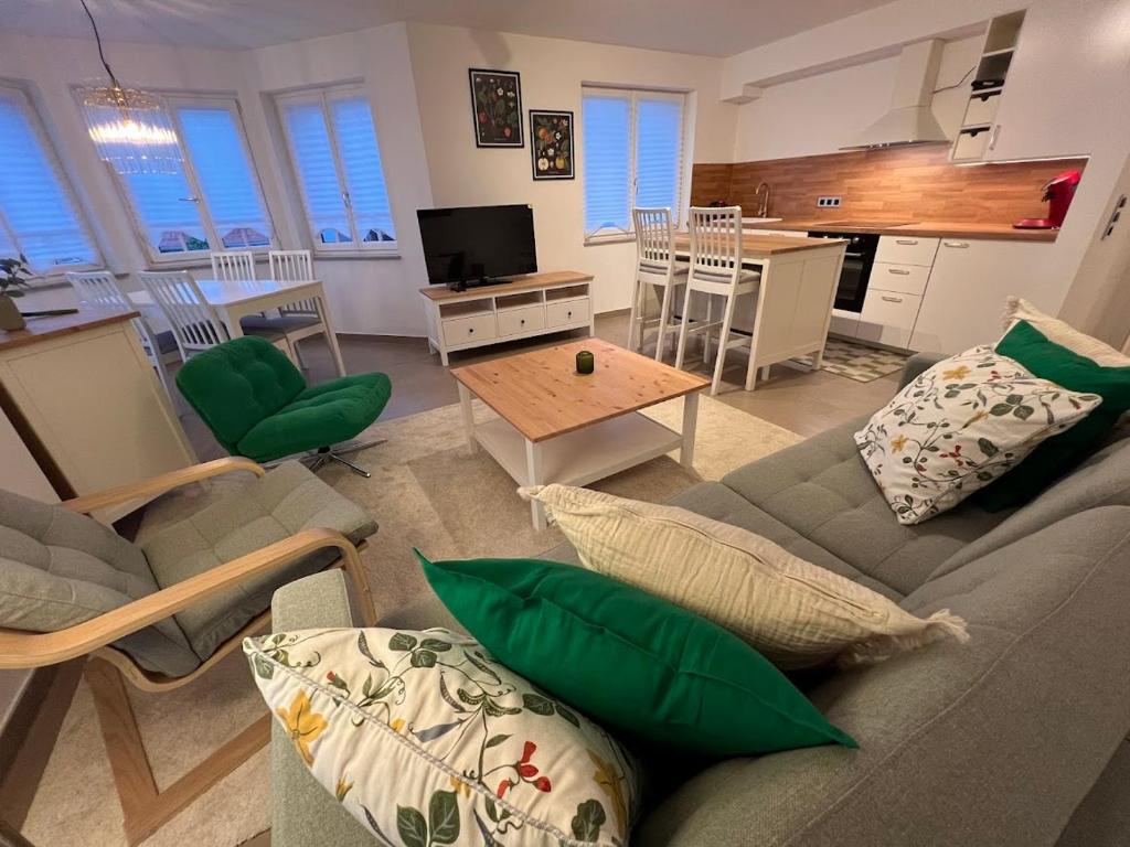 a living room with a couch and a table at Großes Apartment 74m2 mit Balkon & Parkplatz - Steakhouse Esmeralda in Ebersbach-Musbach