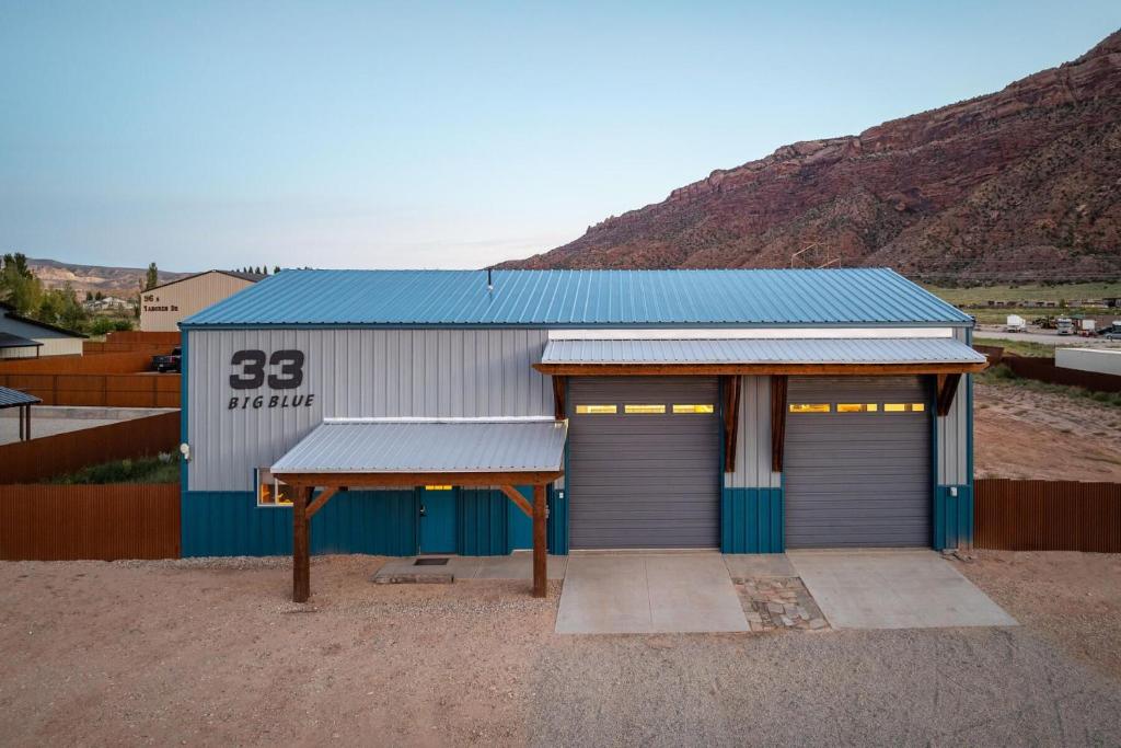 モアブにあるBig Blue - Moab's Adventure Basecamp!のガレージとその前にテーブルがある建物