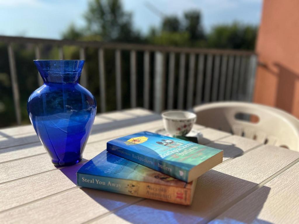 a book and a blue vase sitting on a table at Casa Lilla in Verona