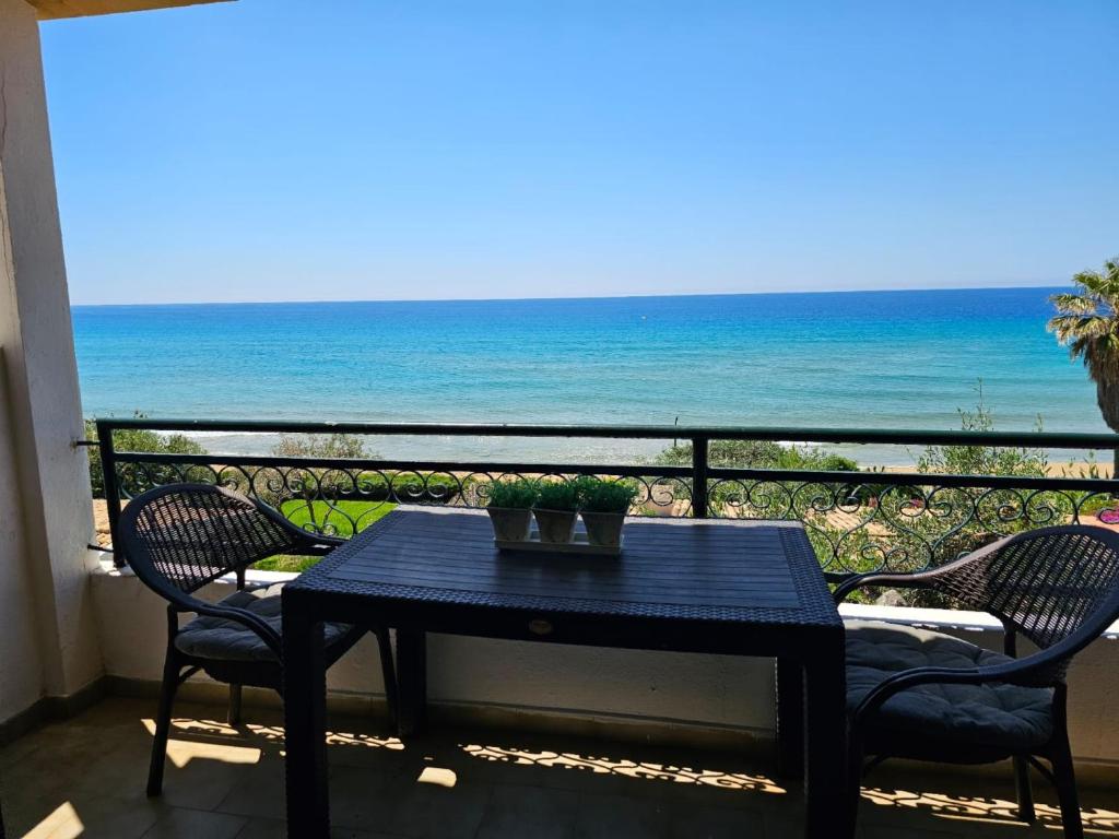 a table and chairs on a balcony with the ocean at Corfu Dream Holidays Villas in Glyfada