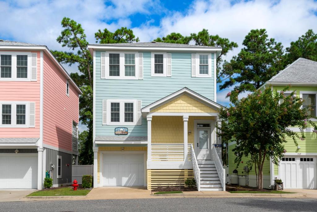 a blue house and two pink houses at Bay Breeze in Kill Devil Hills