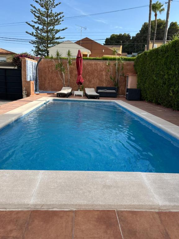 ein Swimmingpool mit blauem Wasser in einem Garten in der Unterkunft Chalet encanto in Chiva