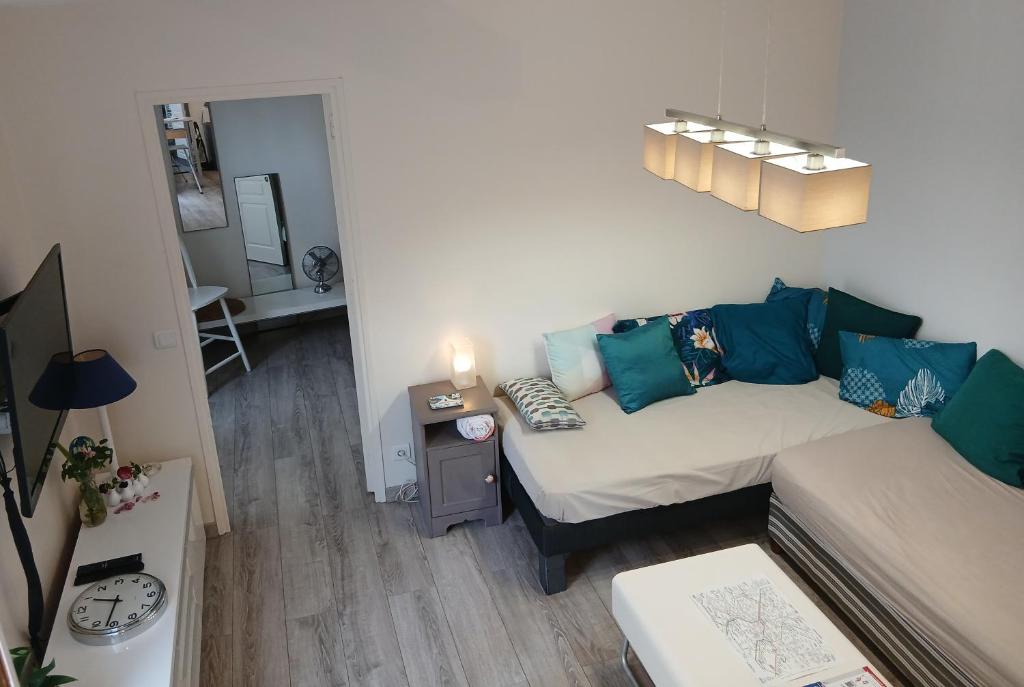 un petit salon avec un canapé et une table dans l'établissement Puces de Vanves, à Malakoff