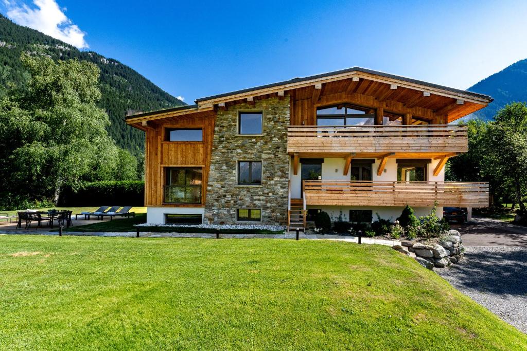 une maison dans les montagnes avec une pelouse verdoyante dans l'établissement Chalet Josephine, Chamonix Les Bois, à Chamonix-Mont-Blanc