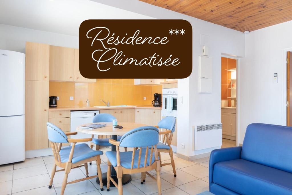 a kitchen and dining room with a table and chairs at Résidence Amaréna in Saint-Paul-lès-Dax