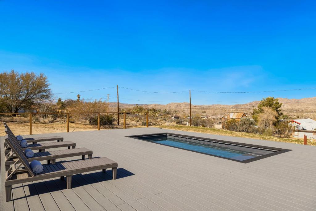 Un patio con dos bancos y una piscina. en Burrobrush Terrace, en Joshua Tree