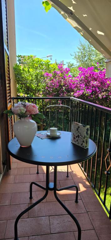 une table bleue sur un balcon fleuri dans l'établissement Ai tre tigli con giardino privato, à Sirolo