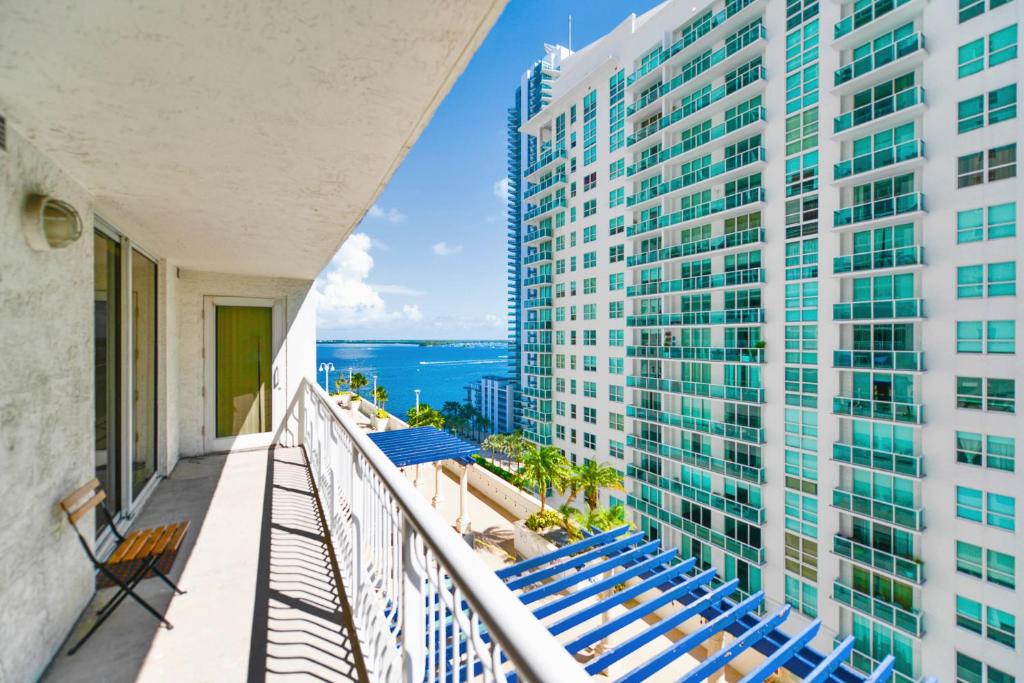 Hotel Trendy 2BR Condo with Pool and Bay Views, a balcony with chairs and a view of a building at Trendy 2BR Condo with Pool and Bay Views in Miami