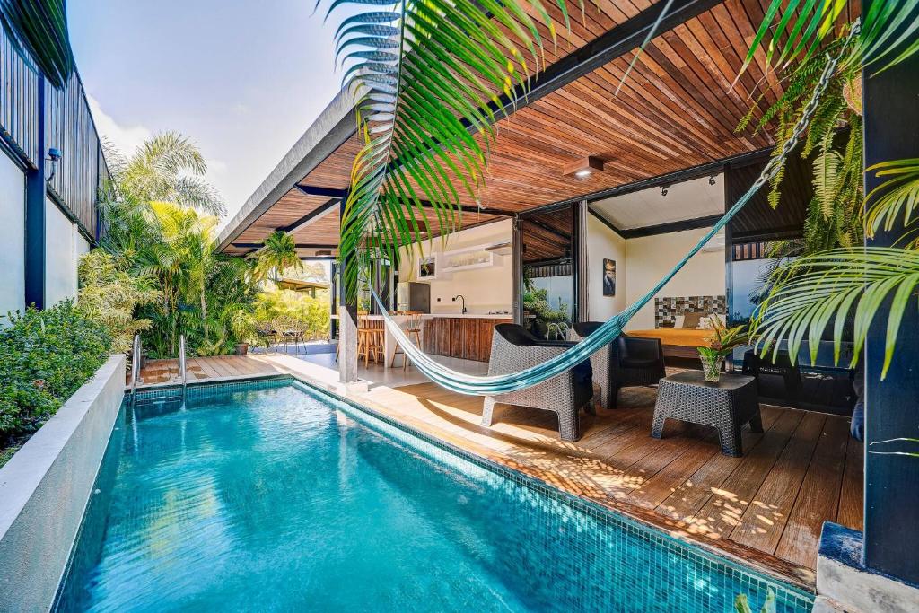 una piscina con una hamaca junto a una casa en Casa Gaviota 1 - Pool, comfort & great location, en Puerto Viejo