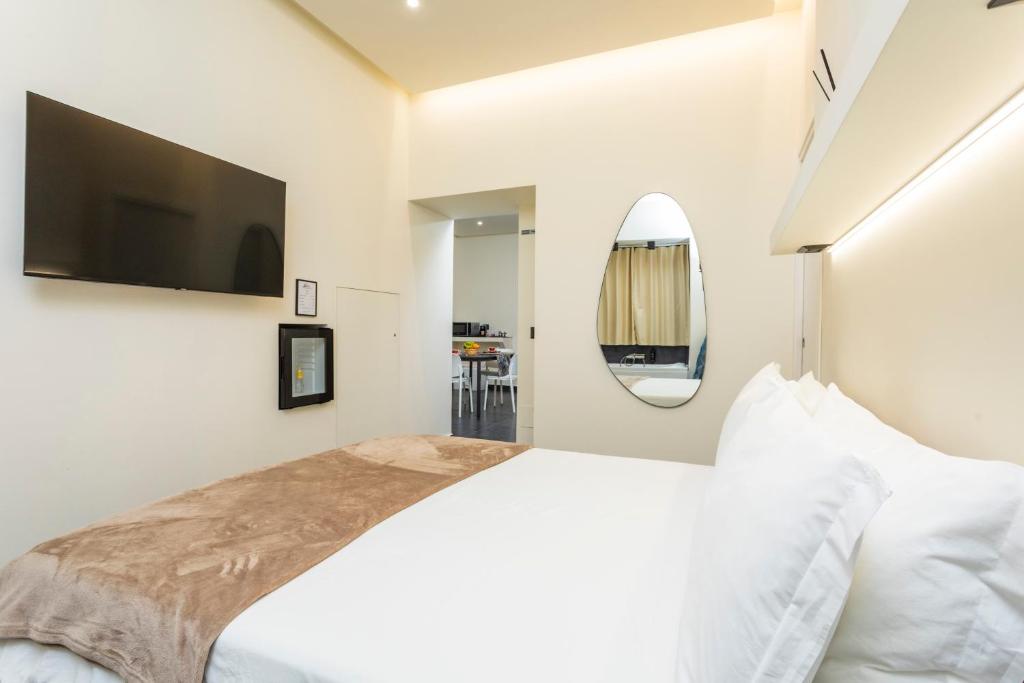a bedroom with a large bed with a flat screen tv at Marina Home - luxury apartament nel cuore di Catania in Catania