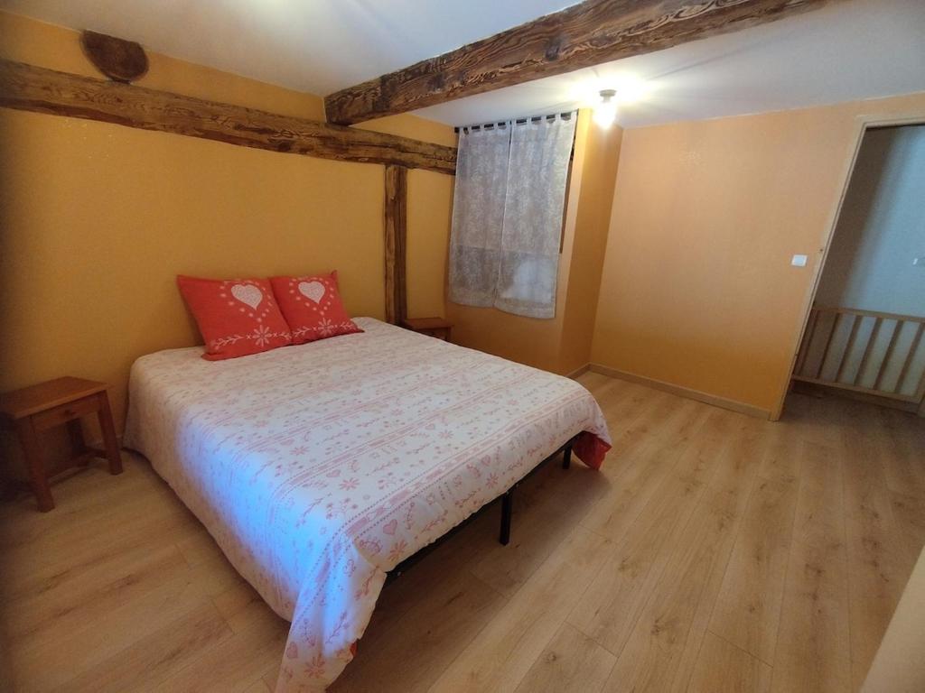 a bedroom with a bed with red pillows on it at Appartement 5 pax à la ferme - Risoul village in Risoul