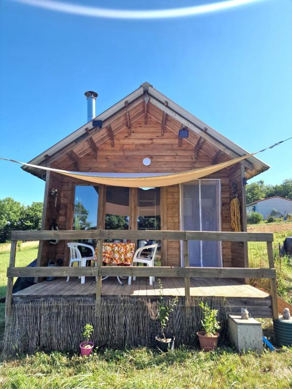 a log cabin with a porch and chairs in the grass at La casita in Villefranque