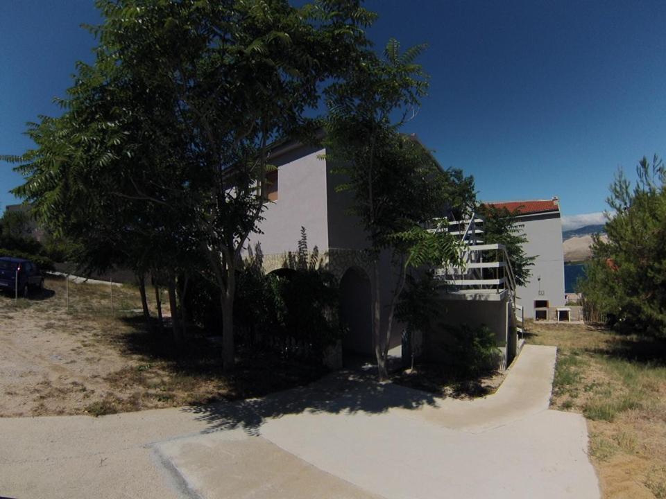 a white house with a tree in front of it at Apartment Twins in Pag