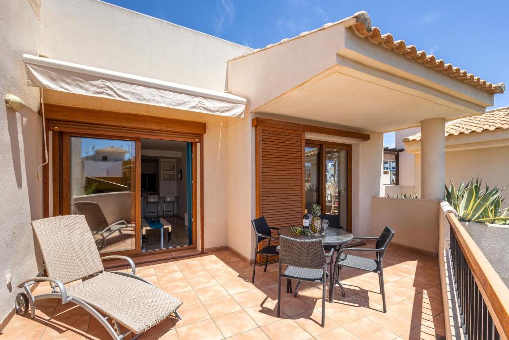 a patio with a table and chairs on a balcony at Apartment Holiday Haven in Punta Prima