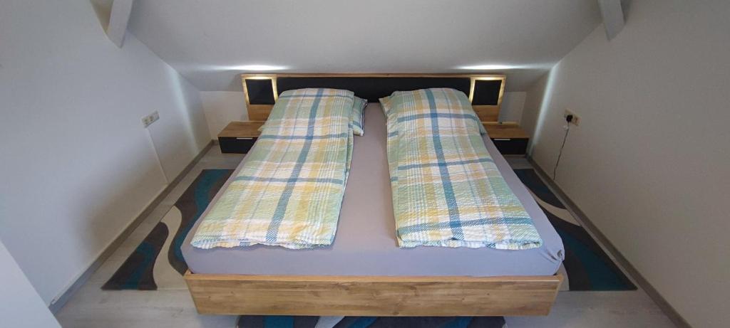 ein kleines Bett in einem kleinen Zimmer mit zwei Kissen in der Unterkunft Antony Home Ferienwohnung in Ostrach