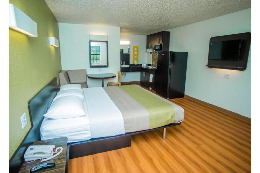 Una habitación de hotel con una cama grande y una cocina. en Motel 6-Palestine, TX, en Palestine