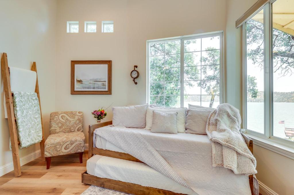 Schlafzimmer mit einem Bett, einem Stuhl und Fenstern in der Unterkunft Clear Lake Getaway with Dock Access and Shared Yard! in Clearlake Oaks