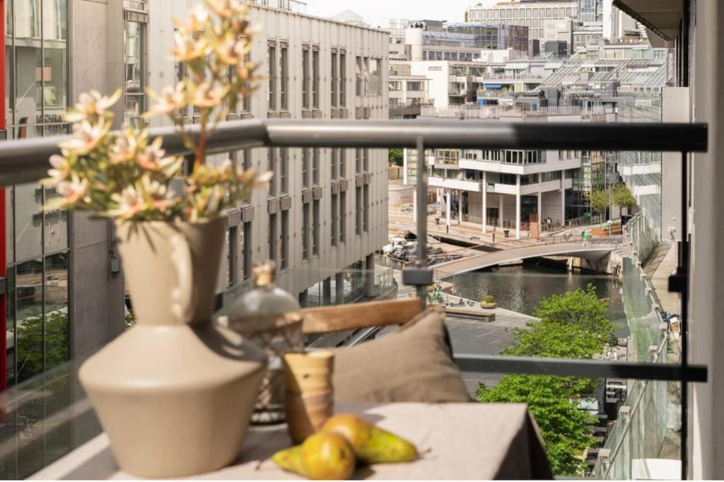 a vase with flowers on a table on a balcony at Tjuvholmen apartment 2BR in Oslo