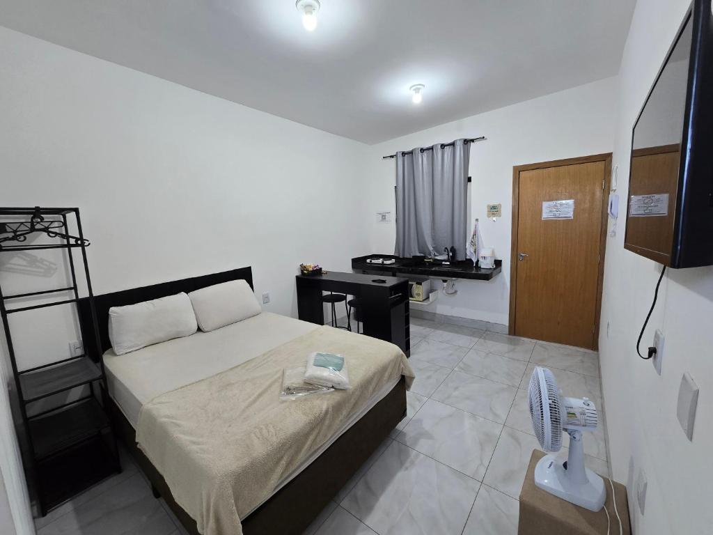 アパレシダ・デ・ゴイアニアにあるFlat completo a 24 minutos do Flamboyant Shoppingのベッドと机が置かれた寝室