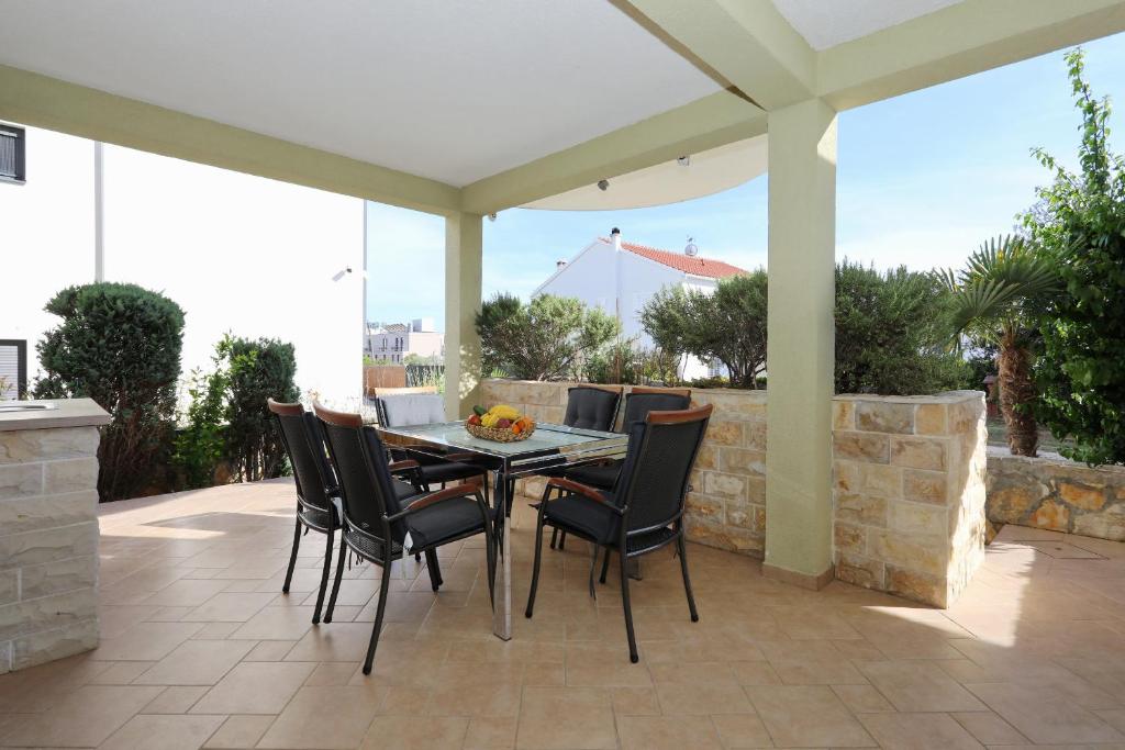 ペトルチャネにあるMare 9 Cozy Two Bedroom Apartment with Gardenのテーブルと椅子のあるパティオ