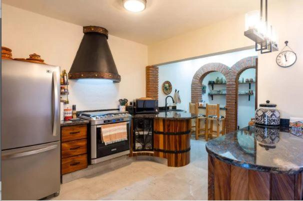 a kitchen with a stainless steel refrigerator and a stove at Los Amores 09 in Bucerías