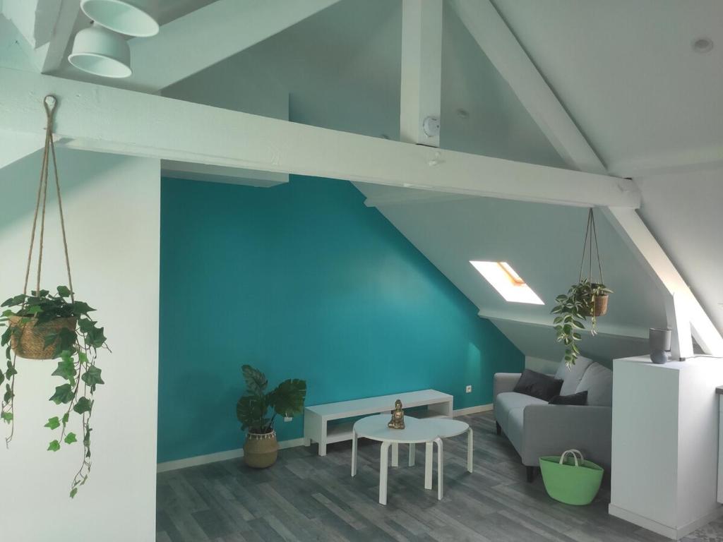 a living room with blue walls and a couch and a table at Loftissime in Dunkerque