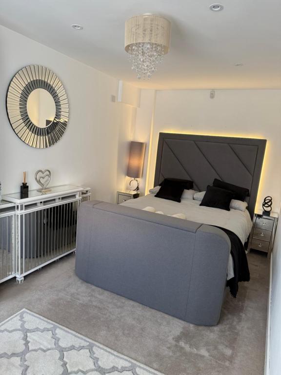 Un dormitorio con una cama grande y un espejo grande. en Edinburgh city break room, en Edimburgo