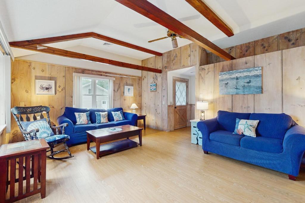 a living room with blue couches and wooden walls at Birch Circle Beach House in Ogunquit