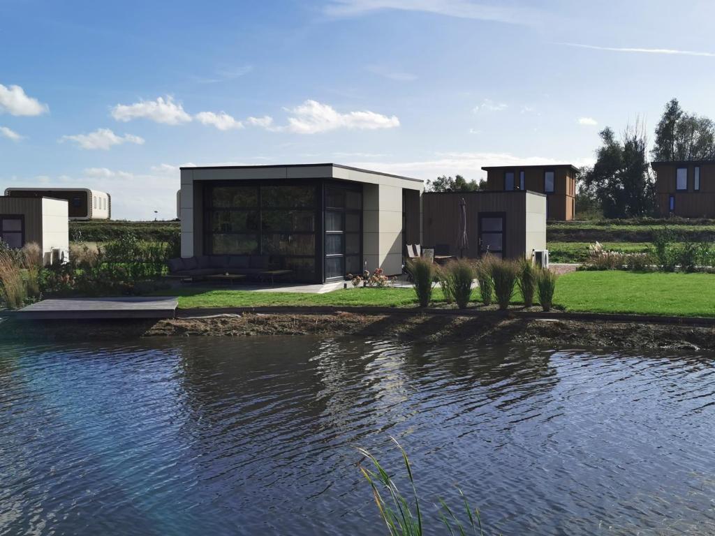 two animals standing on the edge of a body of water at Marina Strandbad Chalet Aan het Oever mit Zaun Haus Nr 135 in Olburgen