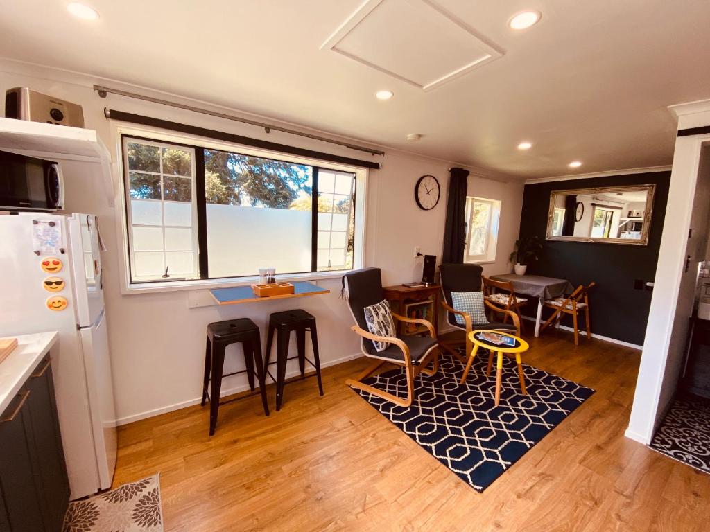ロトルアにあるAdorable Self Contained One Bedroom Studioのテーブルと椅子のあるキッチンとリビングルーム
