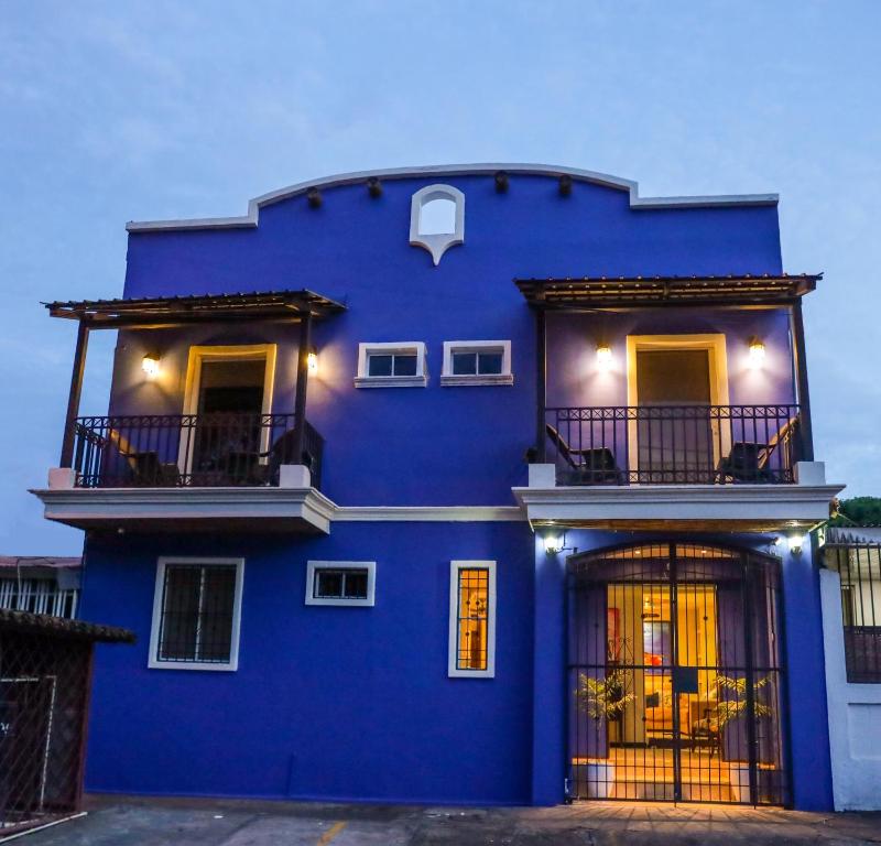 a blue house with a balcony in front of it at Hotel Los Altos Express "La Centroamerica" in Managua