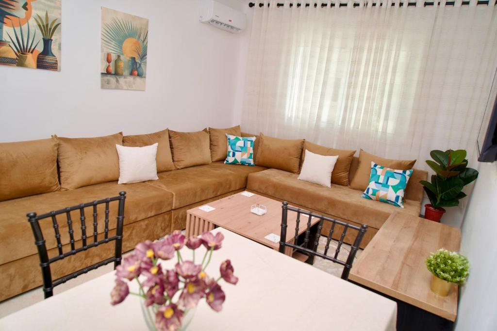 Spacious Family Apartment near Beach & Airport في طنجة: غرفة معيشة بها أريكة وطاولة