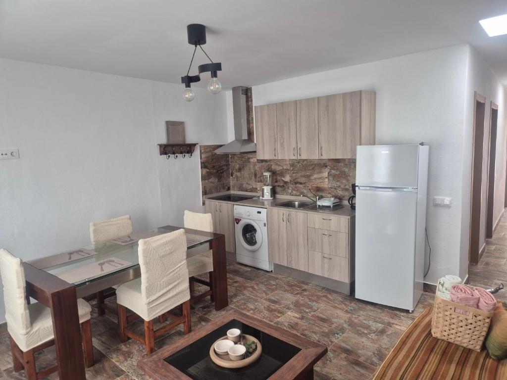 a kitchen and dining room with a table and a refrigerator at Luz del Mar in Orzola