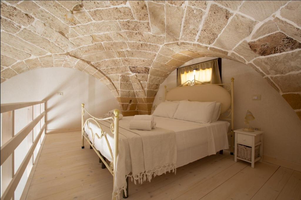 una camera da letto con un letto in un muro di pietra di Dimore Salentine a Felline