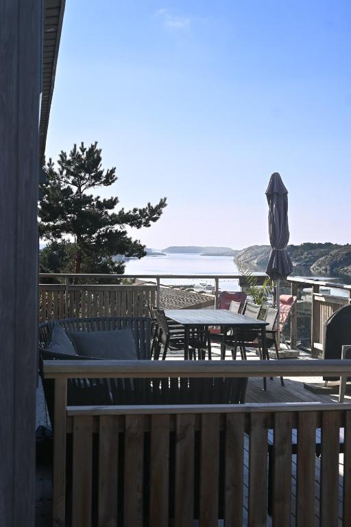 a patio with a table and an umbrella and the ocean at Saltviks Stugby & Camping in Grebbestad