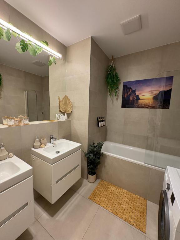 a bathroom with a sink and a tub and a toilet at Oáza Apartmán in Poprad