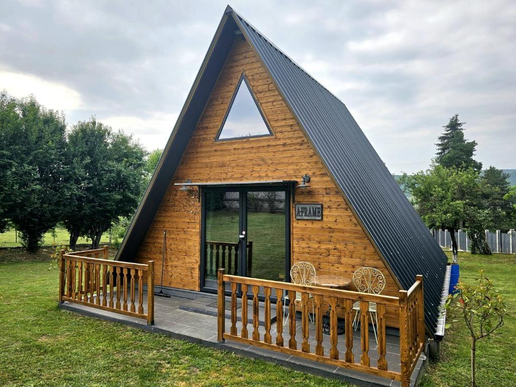 a small house with a triangular roof and a porch at Villa India A-Frame in Ledenik