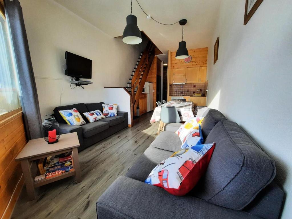 un salon avec un canapé et une télévision dans l'établissement Résidence Caron - Beau 4 pièces duplex à Preyerand MAE-3794, aux Menuires
