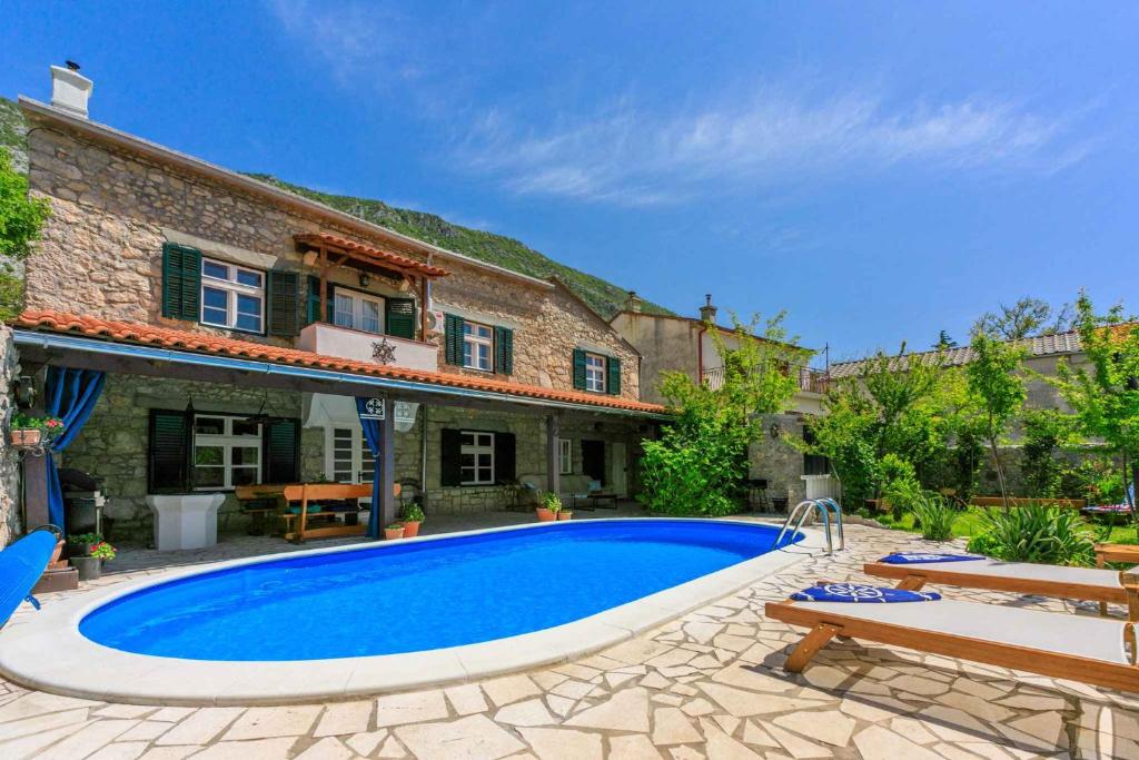 a large swimming pool in front of a house at Holiday home in Drivenik 39517 in Drivenik