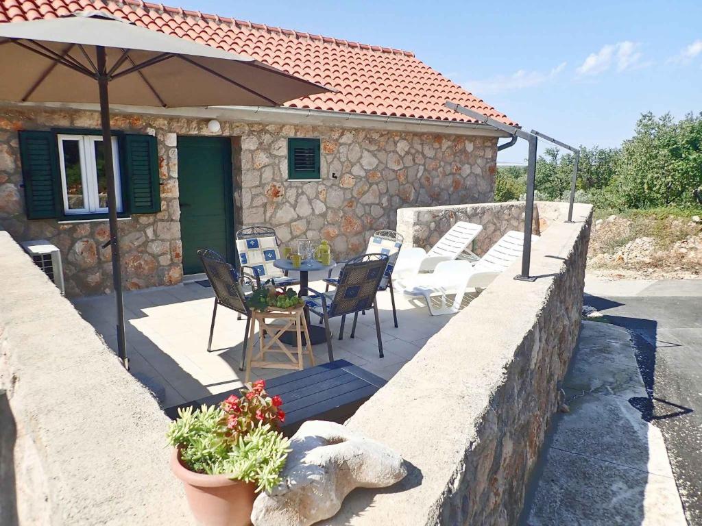 a patio with a table and chairs and an umbrella at Apartment Seline - Paklenica Riviera 35328 in Seline