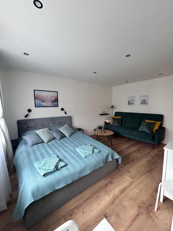 a bedroom with a large bed and a couch at Elegant seaside stay - Vitolu street apartment in Liepāja