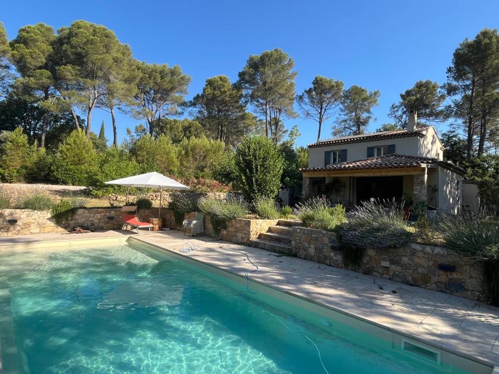 a house with a swimming pool in front of a house at Piscine chauffée, tennis, Mas provençal contemporain in Draguignan