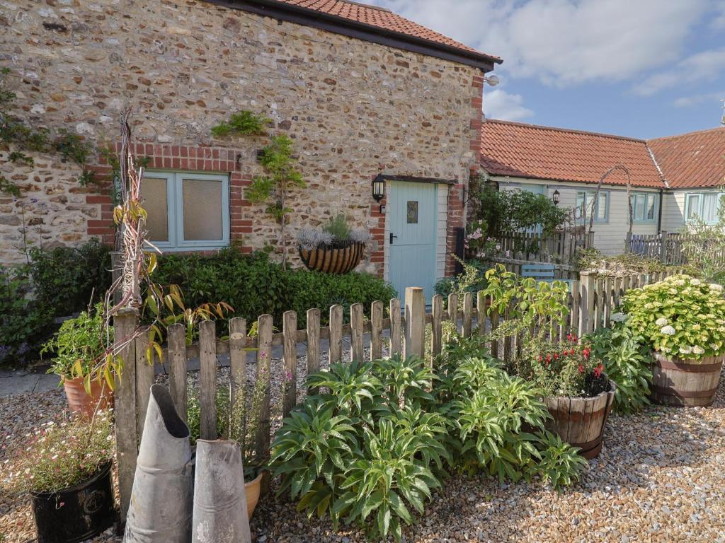 a wooden fence in front of a house with plants at The Hay Loft in Colyton