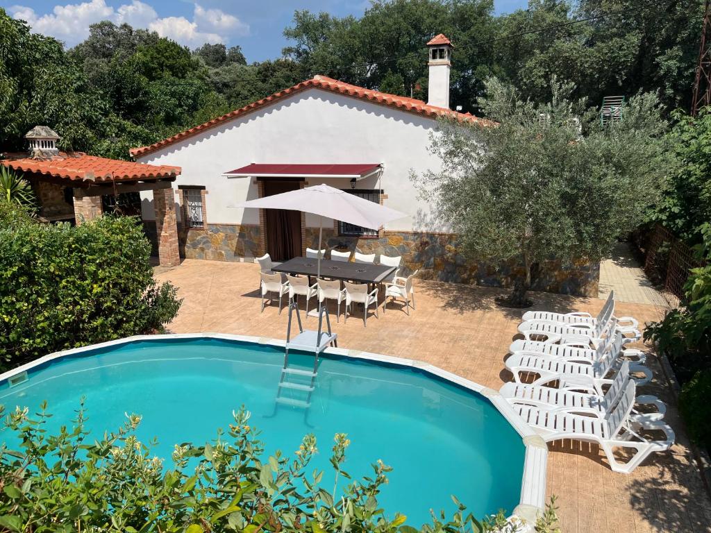 a villa with a pool and a table and chairs at Casa de campo RuralRuñA in Aracena