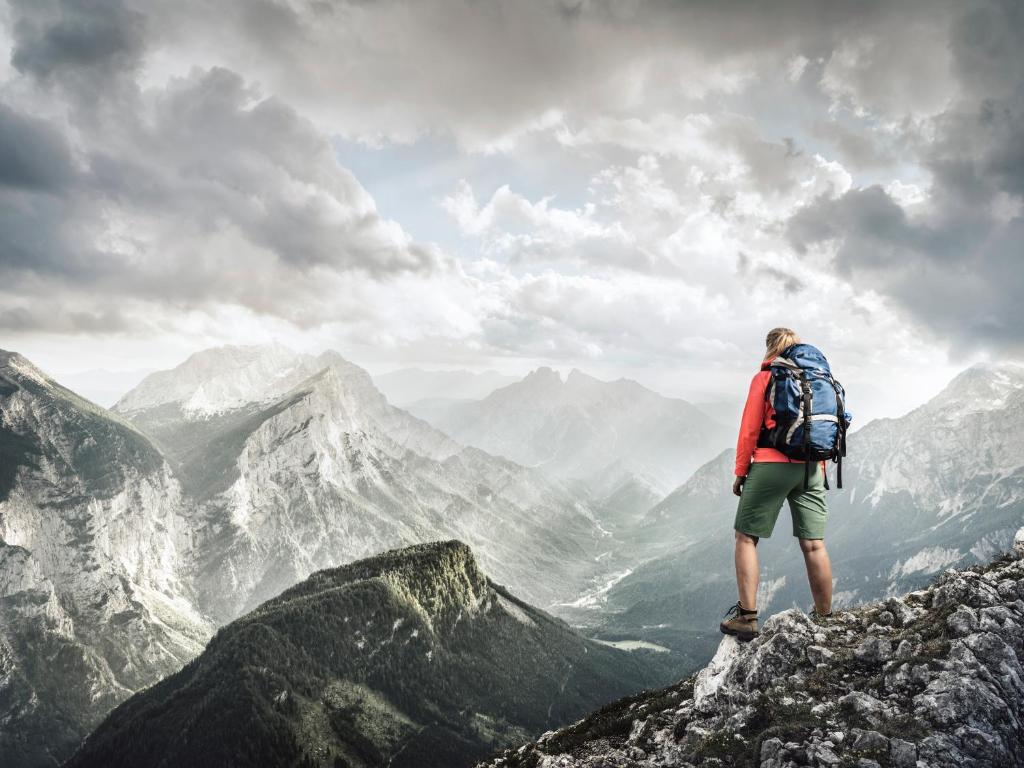 a man with a backpack standing on top of a mountain at Huberbauer in Johnsbach