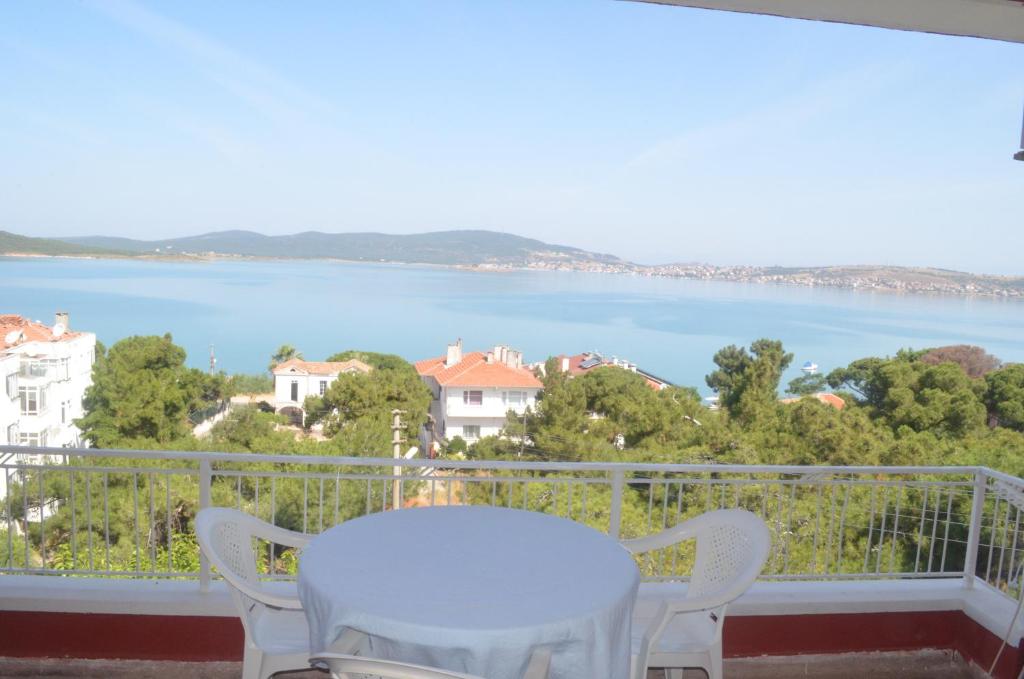 einen Balkon mit einem Tisch und Blick auf das Wasser in der Unterkunft Tunc Hotel in Ayvalık