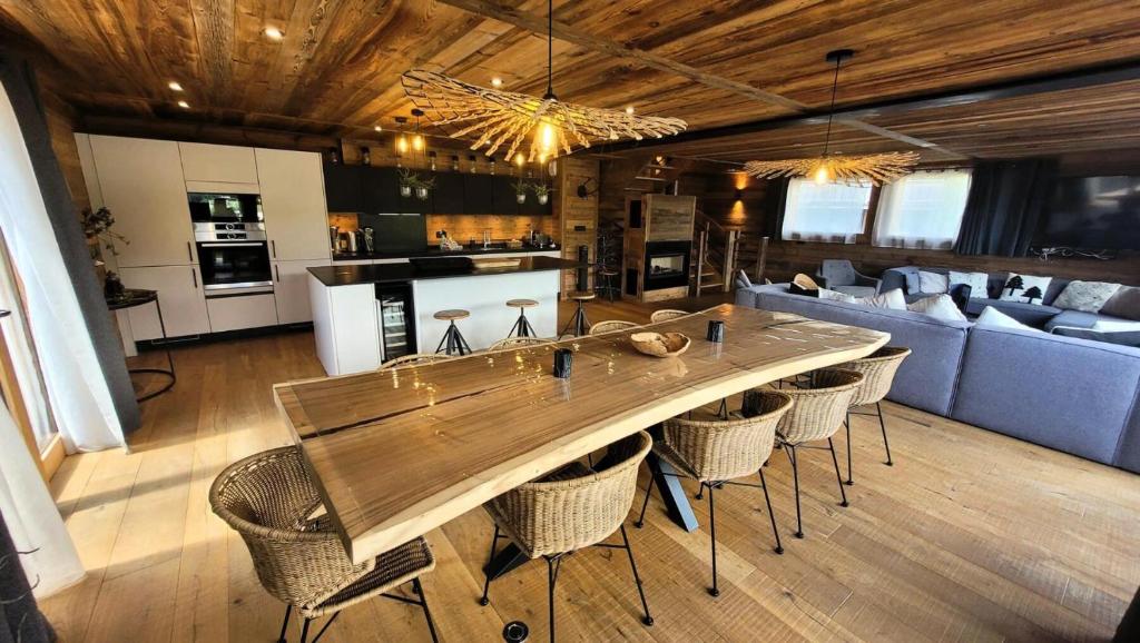 Il dispose d'une cuisine et d'un salon avec une table et des chaises en bois. dans l'établissement Résidence PremiÈre Loge - Magnifique chalet, prestations de qualité, bel emplacement MAE-3371, aux Gets