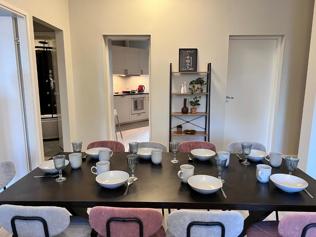 a dining room table with chairs and a black table and a kitchen at Reval Residences City Center in Tallinn